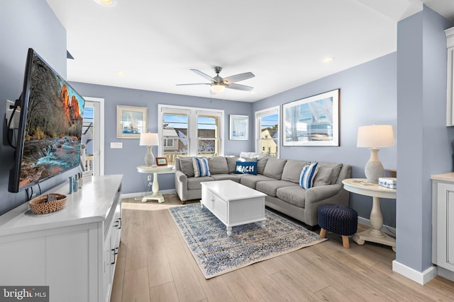 living room with ceiling fan and light wood-type flooring