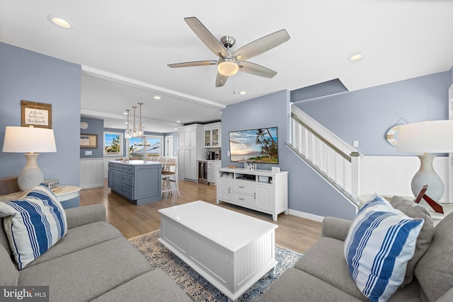 living room with light hardwood / wood-style floors and ceiling fan