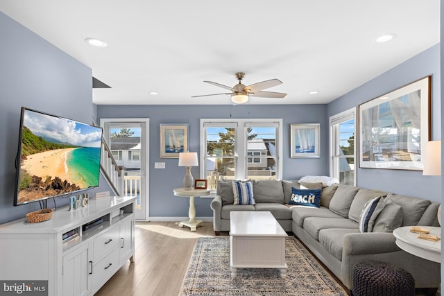 living room featuring ceiling fan and light hardwood / wood-style flooring