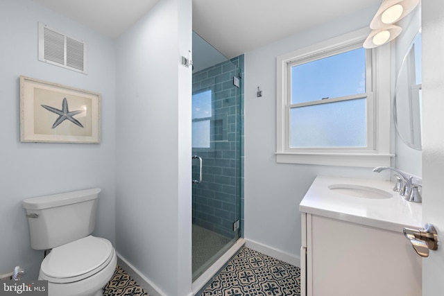 bathroom featuring tile patterned floors, a shower with door, vanity, and toilet