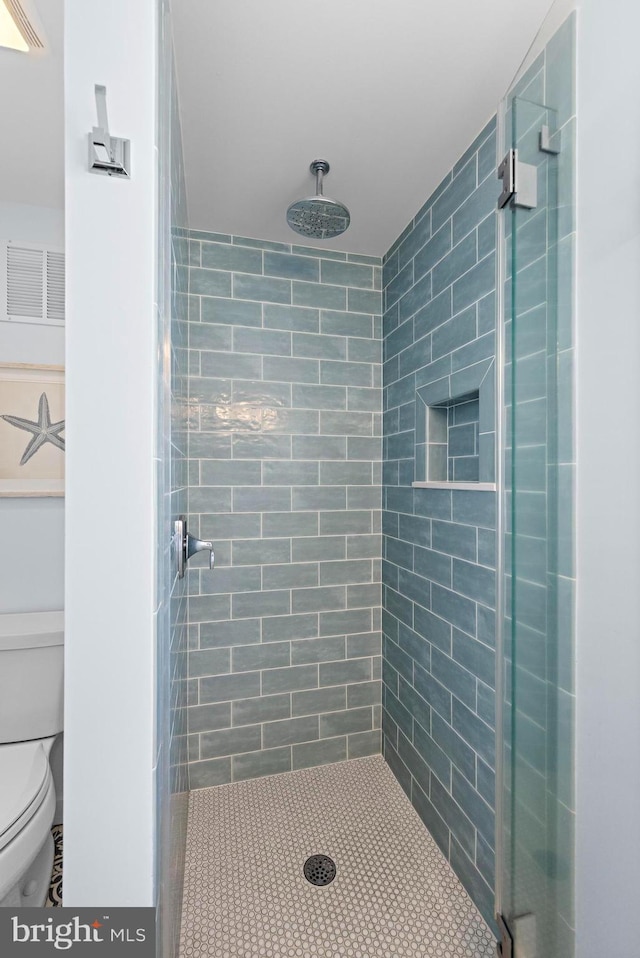 bathroom with toilet and a shower with shower door