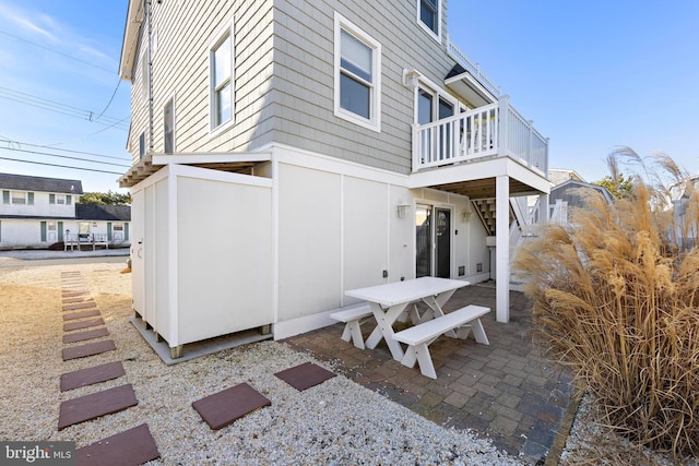 view of side of property featuring a balcony and a patio