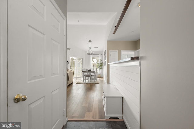 hall featuring beam ceiling, an inviting chandelier, and hardwood / wood-style floors