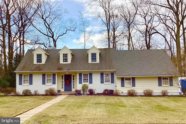 cape cod house featuring a front yard