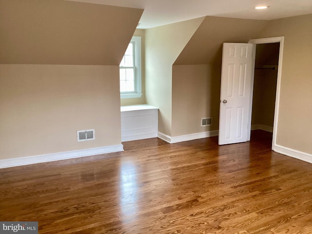 bonus room featuring vaulted ceiling and dark hardwood / wood-style floors