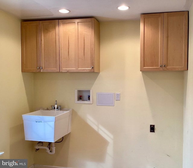 laundry area with sink, electric dryer hookup, hookup for a washing machine, and cabinets