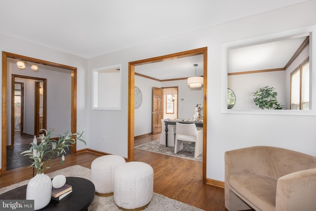 interior space featuring ornamental molding, baseboards, and wood finished floors