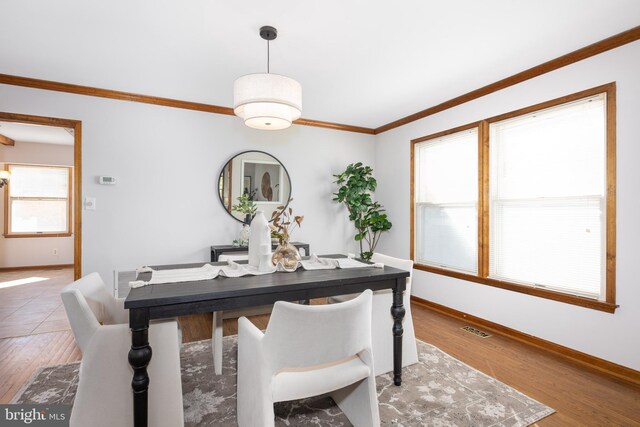 dining room featuring visible vents, wood finished floors, and ornamental molding