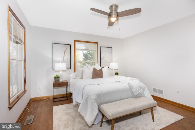 bedroom with visible vents, ceiling fan, baseboards, and wood finished floors