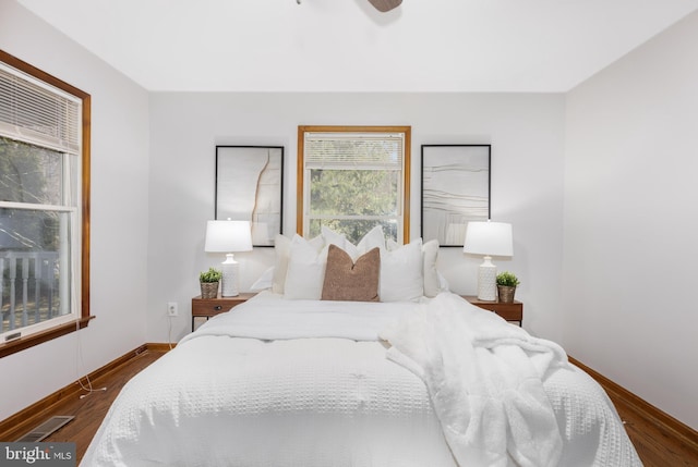 bedroom with a ceiling fan, dark wood-type flooring, baseboards, and visible vents