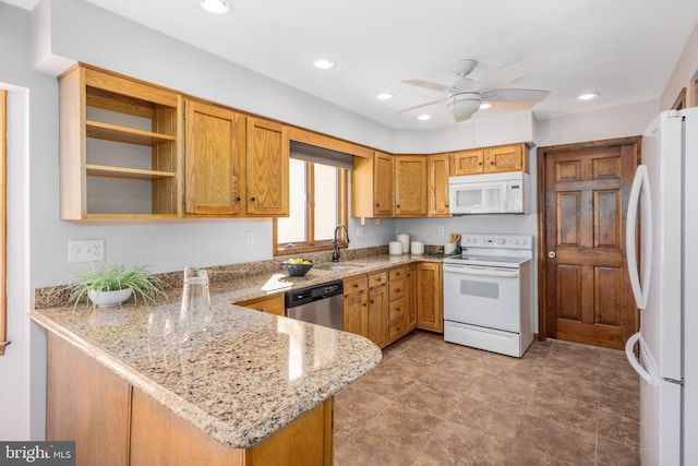 kitchen with light stone counters, recessed lighting, a peninsula, white appliances, and a sink