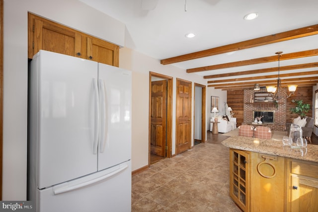 kitchen with beamed ceiling, decorative light fixtures, freestanding refrigerator, recessed lighting, and a fireplace