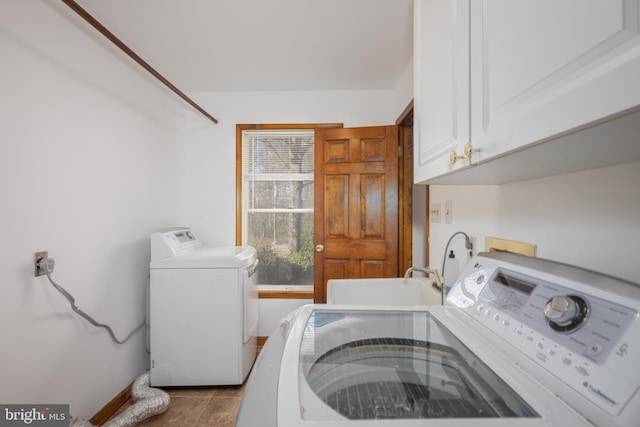 washroom with independent washer and dryer, a sink, cabinet space, tile patterned flooring, and baseboards