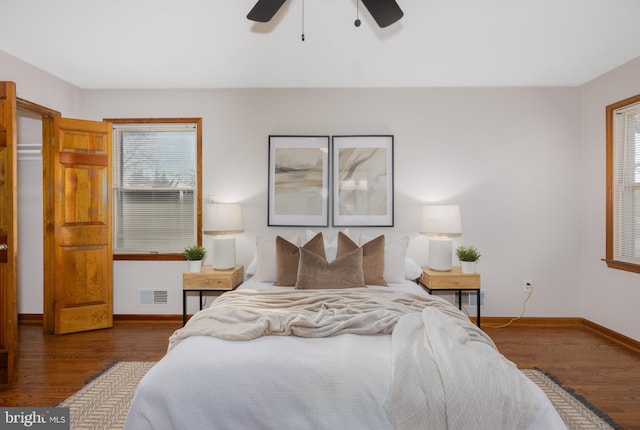 bedroom with visible vents, a ceiling fan, baseboards, and wood finished floors