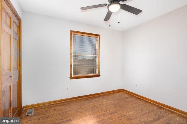 empty room featuring visible vents, baseboards, and wood finished floors