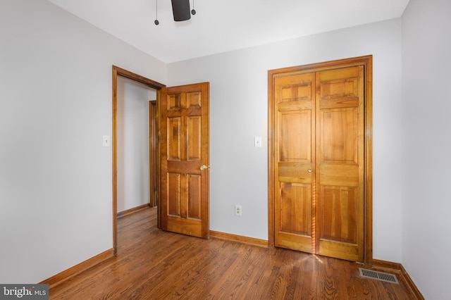 unfurnished bedroom featuring visible vents, baseboards, and wood finished floors