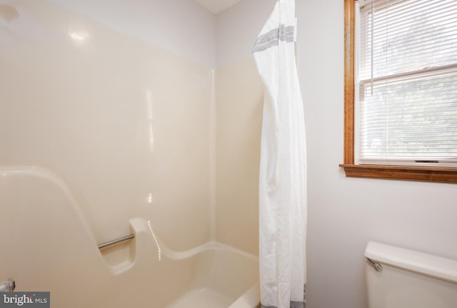 full bathroom with a shower with shower curtain and toilet