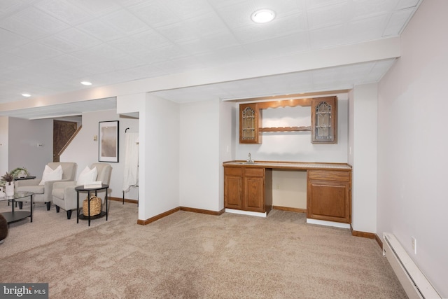 interior space featuring a baseboard radiator, baseboards, light colored carpet, and indoor wet bar