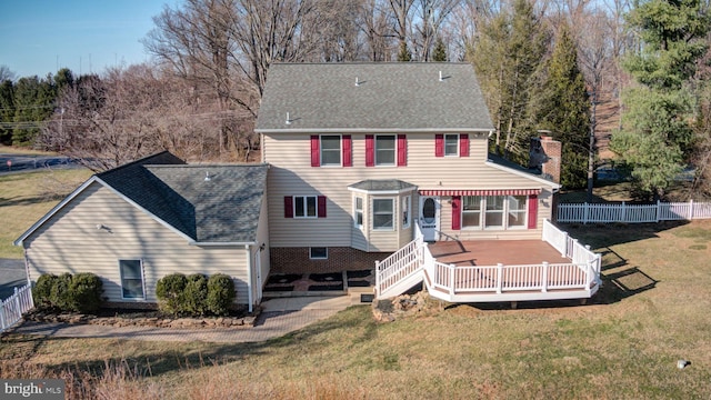 view of front of home with a front lawn, a fenced backyard, roof with shingles, and a chimney