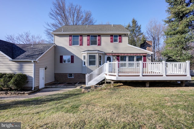 back of house featuring a deck, a yard, roof with shingles, a chimney, and a patio area