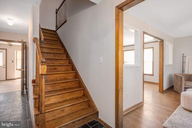 stairway featuring baseboards and wood finished floors