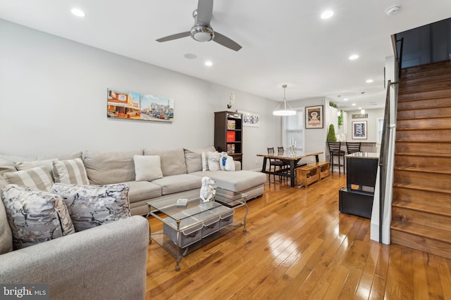 living room with ceiling fan and light hardwood / wood-style flooring