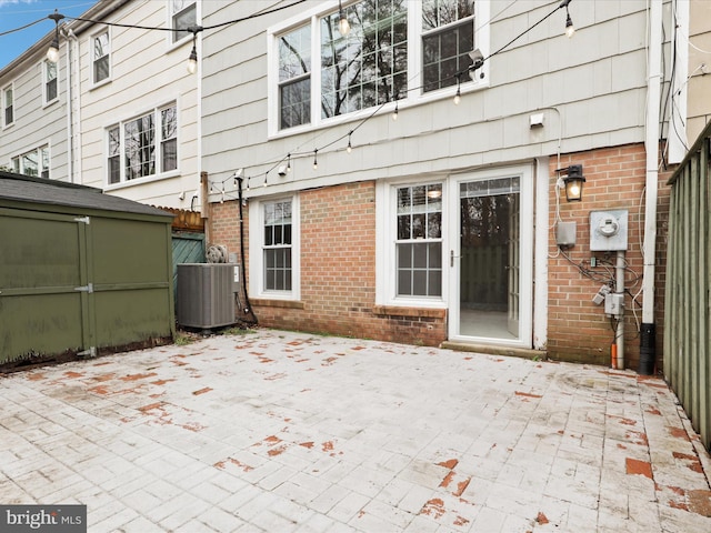 back of house with a shed, central AC unit, and a patio area