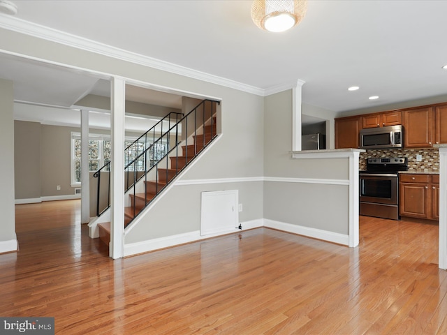 unfurnished living room with ornamental molding and light hardwood / wood-style floors