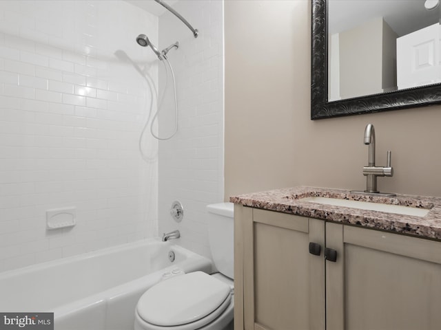 full bathroom featuring tiled shower / bath, vanity, and toilet