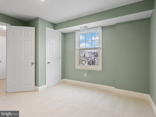 unfurnished bedroom with a closet and light carpet