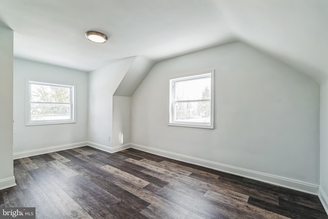 bonus room with vaulted ceiling and dark hardwood / wood-style flooring