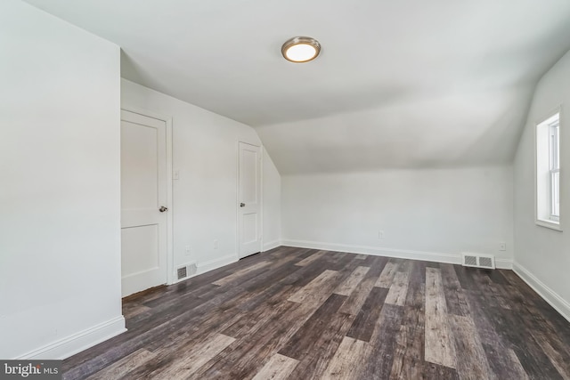 additional living space featuring vaulted ceiling and dark hardwood / wood-style flooring