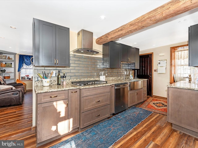 kitchen featuring light stone counters, stainless steel appliances, dark hardwood / wood-style floors, and wall chimney exhaust hood