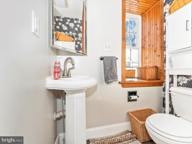 bathroom with wood ceiling, wooden walls, and toilet