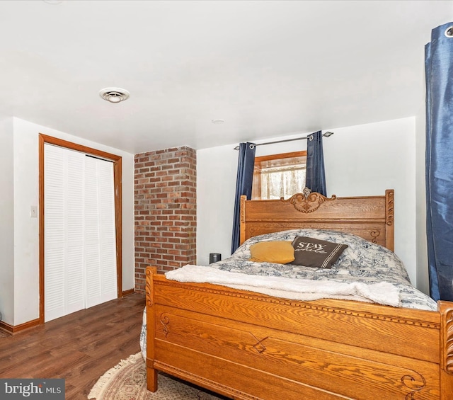 bedroom with dark wood-type flooring and a closet