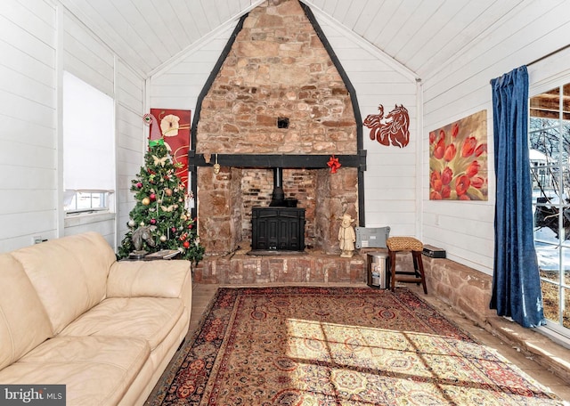 living room with lofted ceiling, a wood stove, and wood walls