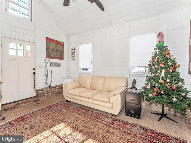 living room with high vaulted ceiling and wood walls