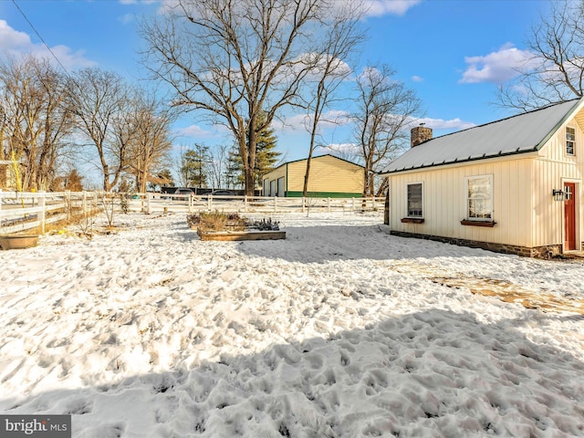 snowy yard featuring an outdoor structure