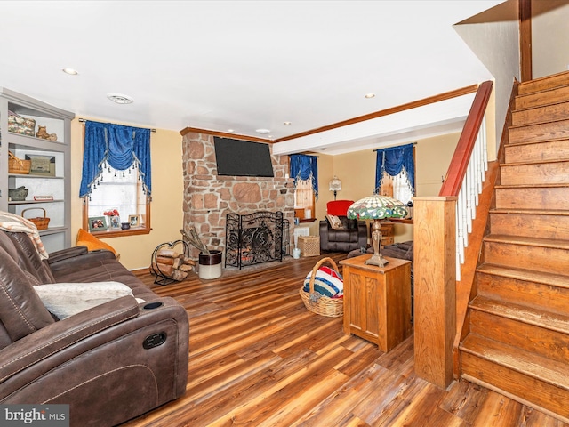 living room with wood-type flooring, a fireplace, and built in shelves