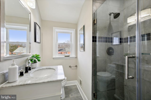 bathroom with toilet, an enclosed shower, and vanity