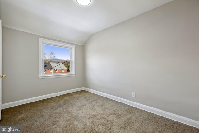 spare room featuring lofted ceiling and carpet floors