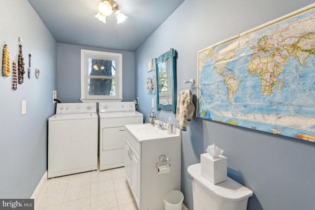 washroom featuring sink, light tile patterned floors, and washing machine and clothes dryer