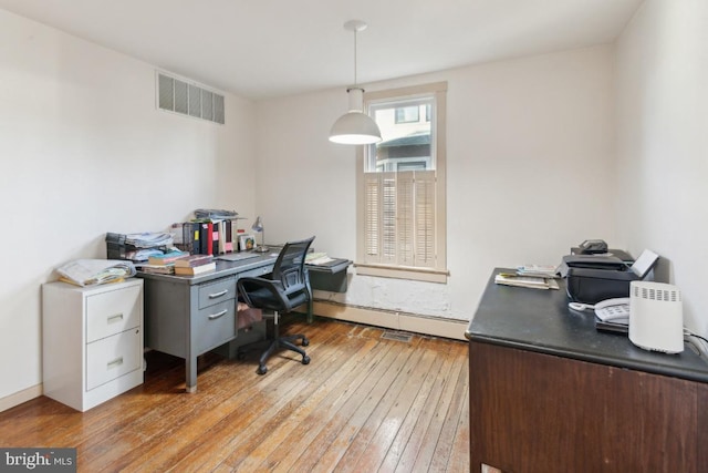 office space with a baseboard radiator and light hardwood / wood-style floors