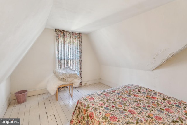 bedroom featuring lofted ceiling and light hardwood / wood-style flooring