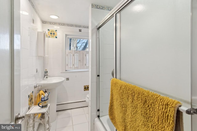 bathroom with bath / shower combo with glass door, tile patterned floors, toilet, and a baseboard heating unit