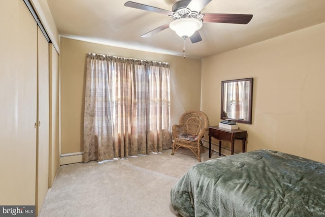 bedroom featuring a closet, light colored carpet, ceiling fan, and baseboard heating