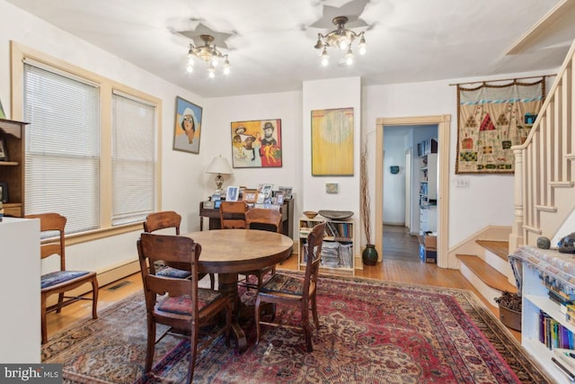 dining space featuring wood-type flooring and a notable chandelier