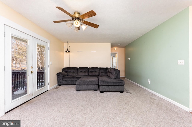 carpeted living room with french doors, ceiling fan, and a textured ceiling