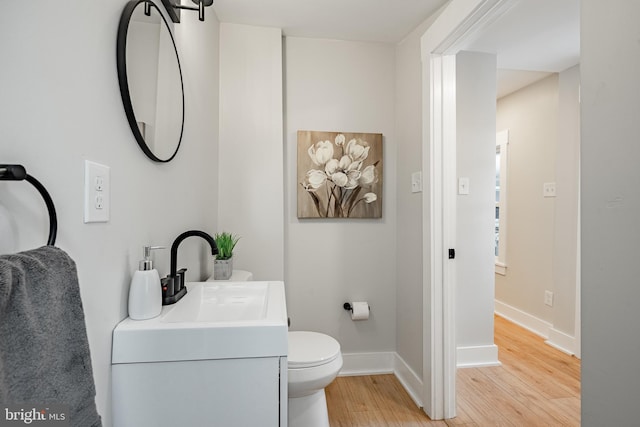 bathroom with vanity, toilet, and wood-type flooring