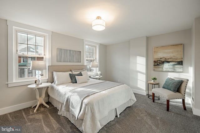 bedroom featuring dark colored carpet and multiple windows